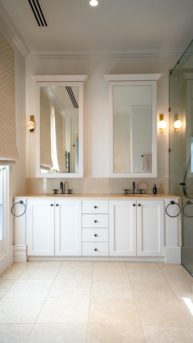 Luxury double vanity bathroom with white cabinetry, marble benchtops and contemporary gold fixtures
