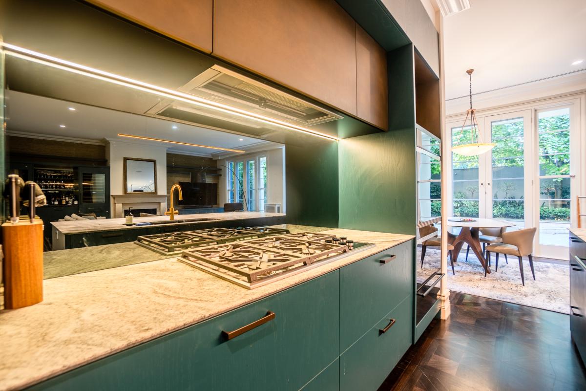 Luxury modern kitchen with sage green cabinetry, marble countertops, and integrated gas hob in Melbourne home