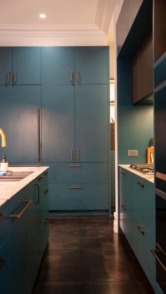 Modern luxury kitchen with sage green cabinetry, brass handles, marble benchtops and integrated appliances